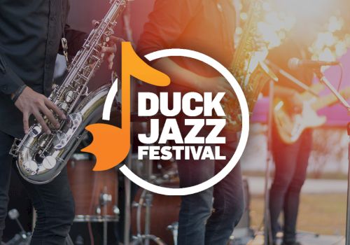 The image shows a logo for the Duck Jazz Festival with musicians playing saxophones and other instruments in the background.