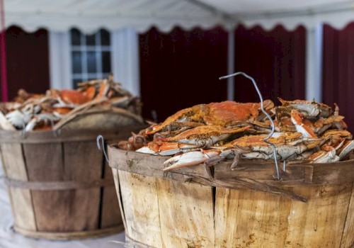 The image shows two wooden baskets filled to the brim with crabs, likely freshly caught or cooked, placed on a table or surface.