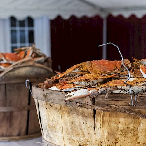 The image shows two wooden baskets filled to the brim with crabs, likely freshly caught or cooked, placed on a table or surface.