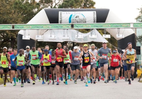 A group of runners starting a marathon, passing under an inflatable archway with 