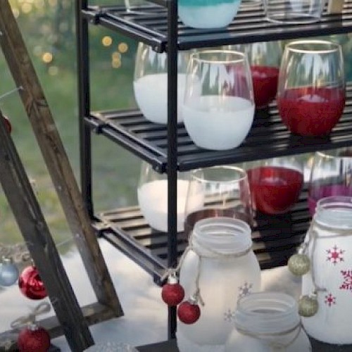 The image shows holiday-themed decorations including jars with painted snowflakes, assorted Christmas ornaments, and colorful candles on shelves.